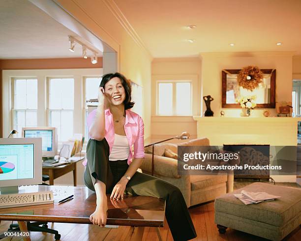 woman sitting on desk - apostrophe stock pictures, royalty-free photos & images