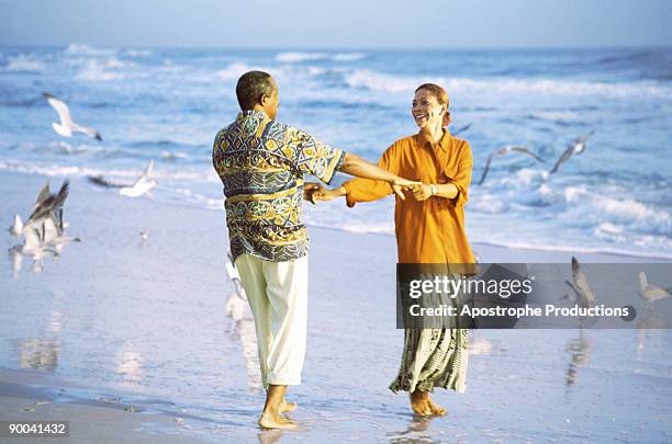 couple dancing on beach - apostrophe stock pictures, royalty-free photos & images