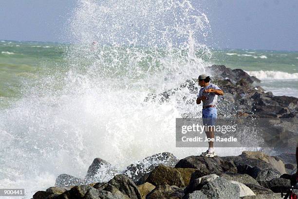 Fisherman braves the waves on a rocky jetty as Hurricane Michelle creates high winds and big waves November 3, 2001 in Miami, FL.