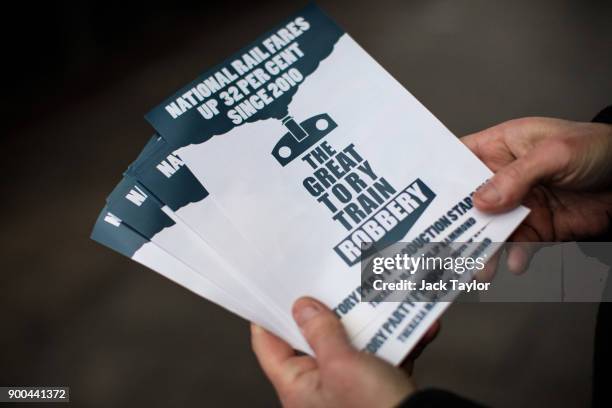 Campaigner poses with leaflets about rail fare increases as he hands them out to commuters outside East Dulwich Station on January 2, 2018 in London,...