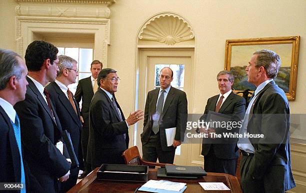 Secretary of Transportation Norman Mineta talks with US President George W. Bush and members of the White House staff October, 2001 in the Oval...