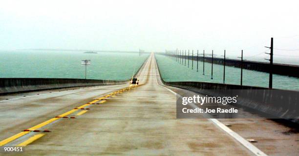 One car travels north on the Seven Mile Bridge November 4, 2001 as Hurricane Michelle approaches the Florida Keys. The hurricane is sustaining 140...