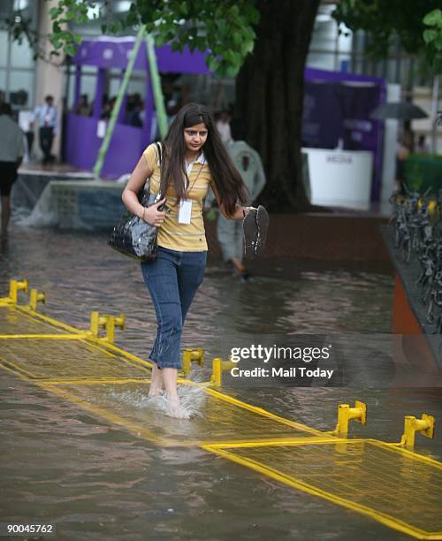Girl wades through a water-logged road in Delhi which witnessed a heavy downpour on Friday afternoon, August 21, 2009.