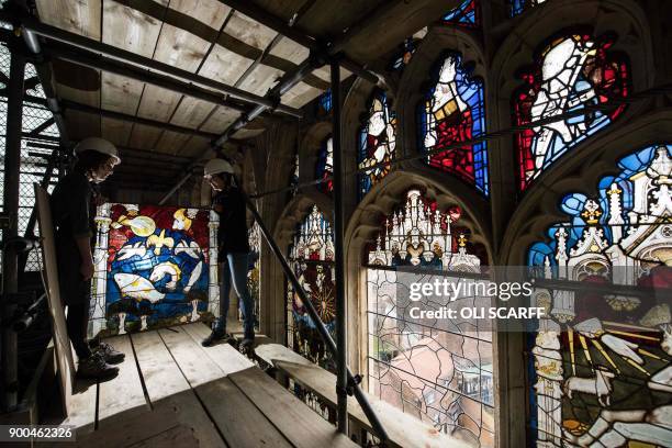 Conservators Zoe Harrigan and Anna Milsom replace the final stained glass panel in York Minster's 600 year-old Great East Window, following a 10-year...