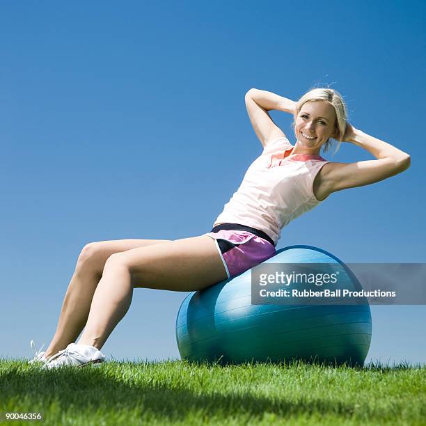 woman exercising with a swiss ball - yoga ball outside stock pictures, royalty-free photos & images