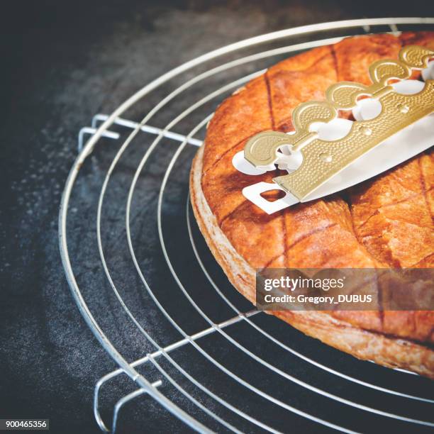 homemade epiphany king's cake pastry close-up with traditional gold paper crown - king cake stock pictures, royalty-free photos & images