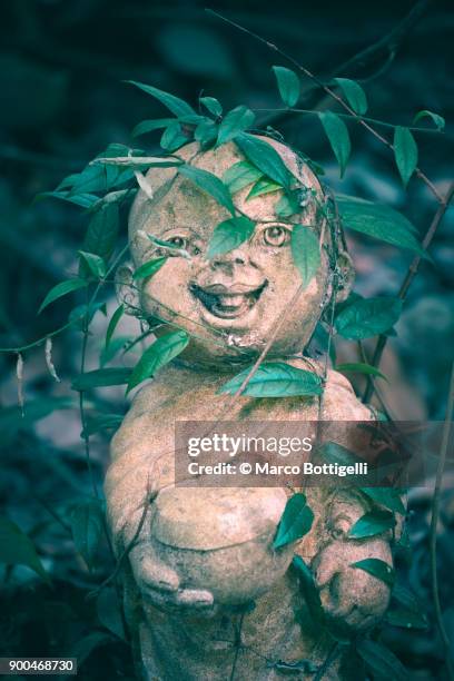 smiling child statue in a buddhist temple, thailand. - thorn like stock pictures, royalty-free photos & images
