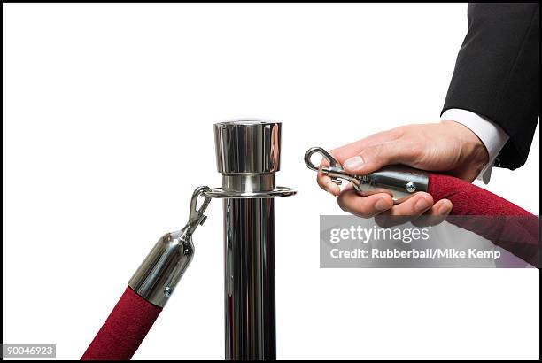 man in a tuxedo next to a velvet rope - roped off stock pictures, royalty-free photos & images