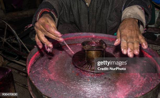 Ghulam Muhammad Bhat makes cotton candy or candy floss on his his typical machine, inside his home, on January 2 in Srinagar, the summer capital of...