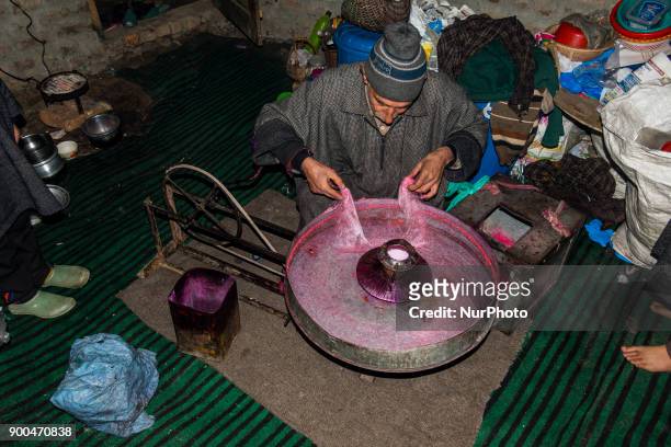 Ghulam Muhammad Bhat makes cotton candy or candy floss on his his typical machine, inside his home, on January 2 in Srinagar, the summer capital of...