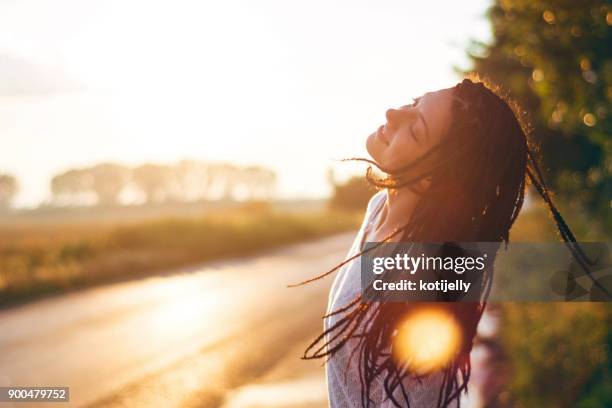 bella giovane donna che si gode il tramonto - aura foto e immagini stock