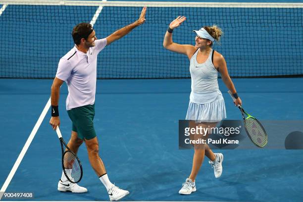 Roger Federer and Belinda Bencic of Switzerland celebrate a point in the mixed doubles match against Anastasia Pavlyuchenkova and Karen Khachanov of...