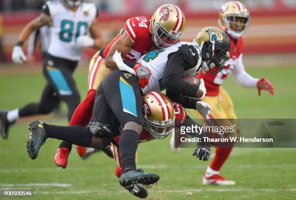 Yeldon of the Jacksonville Jaguars gets tackled by K'Waun Williams and Ahkello Witherspoon of the San Francisco 49ers during their NFL football game...