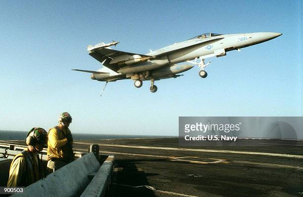 Navy arresting gear officers observe the landing of an F/A-18 "Hornet" November 6, 2001 on the flight deck of the USS Theodore Roosevelt. The USS...