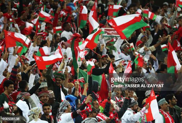Omani fans wave their national flag as they celebrate after their national team scored a goal during the 2017 Gulf Cup of Nations semi-final football...
