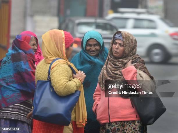 People brave through a cold weather amid heavy fog at Mayur Vihar, on January 2, 2018 in New Delhi, India. Cold wave conditions continued to sweep...