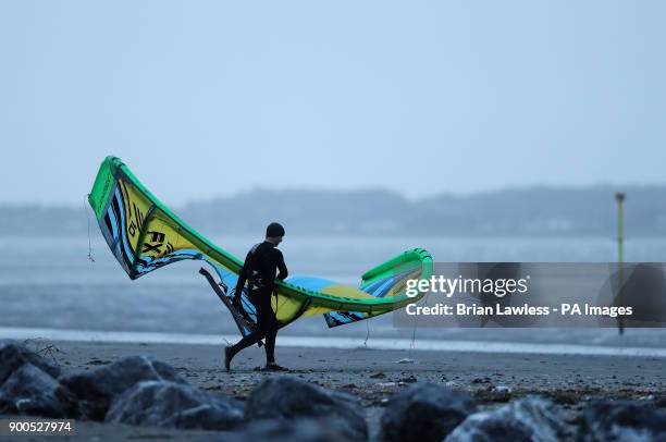 Kite surfer makes his way to the water on Dollymount strand in Dublin as winds start to pick up.