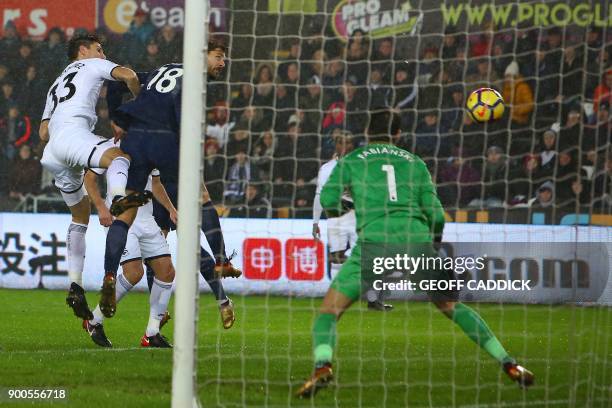 Tottenham Hotspur's Spanish striker Fernando Llorente heads past Swansea City's Polish goalkeeper Lukasz Fabianski for Tottenham's first goal during...