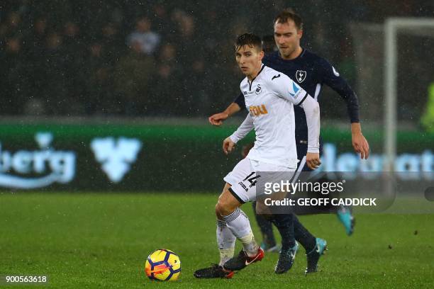 Swansea City's English midfielder Tom Carroll vies with Tottenham Hotspur's Danish midfielder Christian Eriksen during the English Premier League...