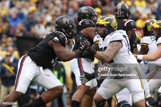 South Carolina Gamecocks defensive lineman Keir Thomas and Michigan Wolverines offensive lineman Mason Cole in action during the 2018 Outback Bowl...