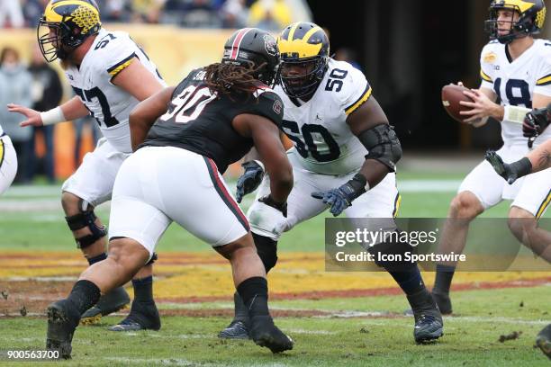 Michigan Wolverines offensive lineman Michael Onwenu blocks South Carolina Gamecocks defensive lineman Taylor Stallworth during the 2018 Outback Bowl...