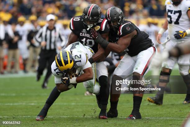 Michigan Wolverines running back Chris Evans is tackled by South Carolina Gamecocks linebacker Skai Moore and South Carolina Gamecocks defensive...