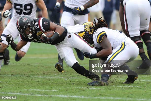 South Carolina Gamecocks running back A.J. Turner is tackled by Michigan Wolverines linebacker Devin Bush during the 2018 Outback Bowl between the...