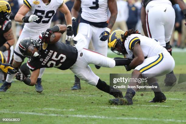 South Carolina Gamecocks running back A.J. Turner is tackled by Michigan Wolverines linebacker Devin Bush during the 2018 Outback Bowl between the...
