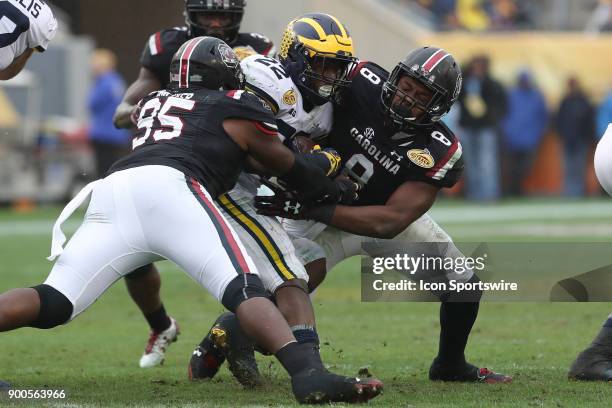 Michigan Wolverines running back Karan Higdon is tackled by South Carolina Gamecocks defensive lineman Dante Sawyer and South Carolina Gamecocks...