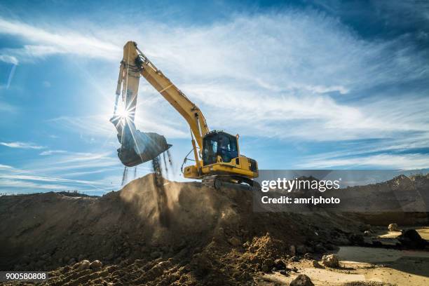 construction - digger working at building site on sunny day - construction machinery stock pictures, royalty-free photos & images