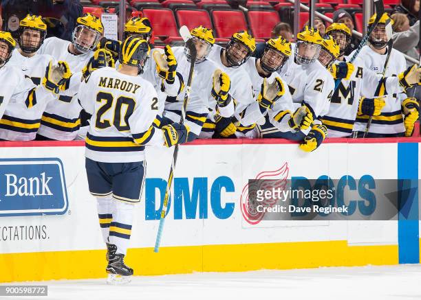 Cooper Marody of the Michigan Wolverines celebrates a goal with teammates on the bench after his third period hat trick goal against the Michigan...