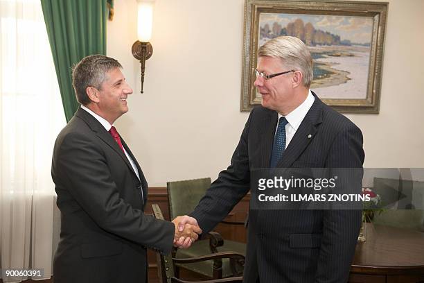 Austrian Foreign Minister Michael Spindelegger and President of Latvia Valdis Zatlers shake hands ahead their meeting in Riga on August 25, 2009. AFP...