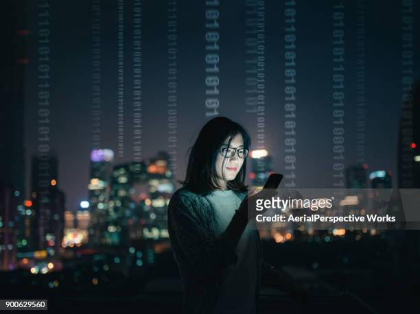 femme avec smartphone debout sur le toit du gratte-ciel - bytes photos et images de collection