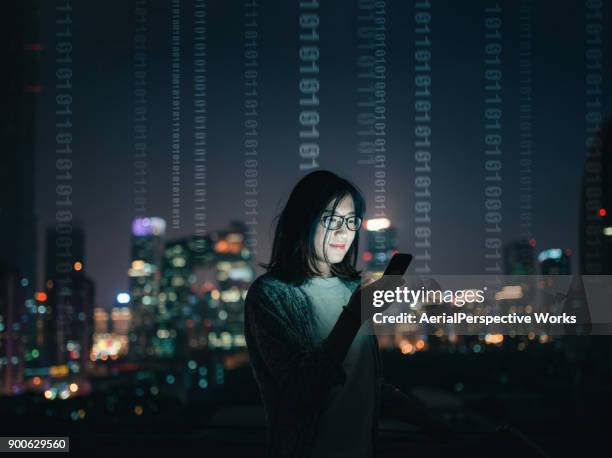 woman with smartphone standing on skyscraper roof - código binário imagens e fotografias de stock