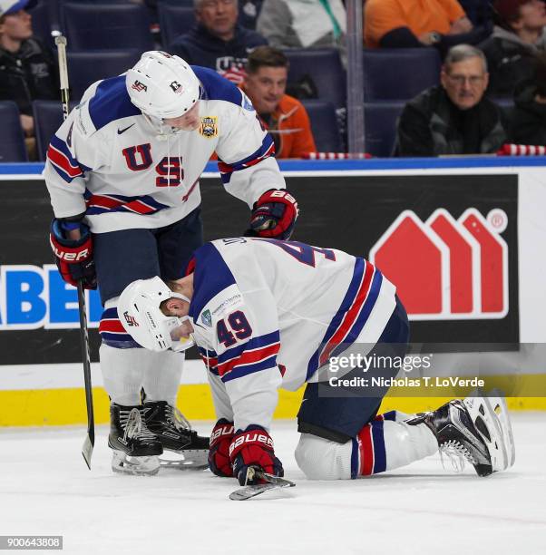 Adam Fox of United States checks on teammate Max Jones after Jones was hit in the head with an elbow against Russia during the first period of play...