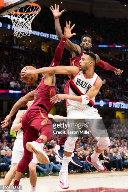 Evan Turner of the Portland Trail Blazers passes around Dwyane Wade and Jeff Green of the Cleveland Cavaliers during the second half at Quicken Loans...