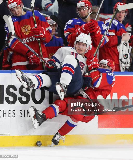 Ryan Lindgren of United States takes a big hit from Andrei Altybarmakyan of Russia during the second period of play in the Quarterfinal IIHF World...