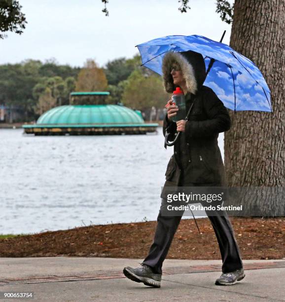 With frigid temperatures blanketing most of the country, a pedestrian in Lake Eola Park bundles up against the chill, in Orlando, Fla., on Tuesday,...