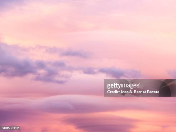 full frame of the low angle view of clouds of colors in sky during sunset. valencian community, spain - rosa stock-fotos und bilder