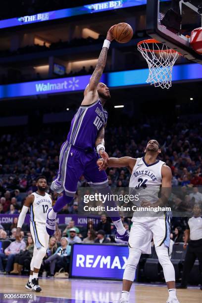 Willie Cauley-Stein of the Sacramento Kings dunks over Brandan Wright of the Memphis Grizzlies at Golden 1 Center on December 31, 2017 in Sacramento,...