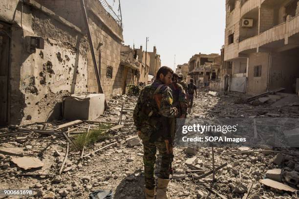 Fighters walking toward centrum of Raqqa city. The overwhelming destruction of Raqqa speaks of a place that has been through more than just war. The...