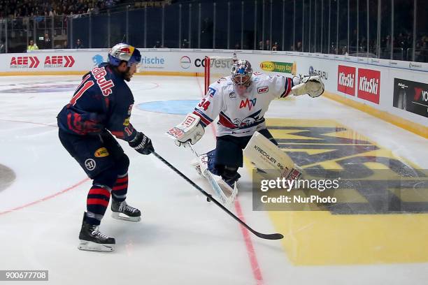 Keith Aucoin of Red Bull Munich vies Chet Pickard of Adler Mannheim during the 38th game day of the German Ice Hockey League between Red Bull Munich...