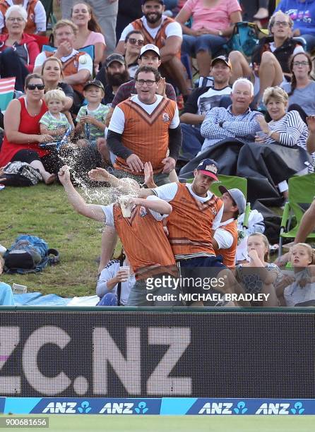 Members of the crowd try to take a catch during the third Twenty20 international cricket match between New Zealand and the West Indies at Bay Oval in...