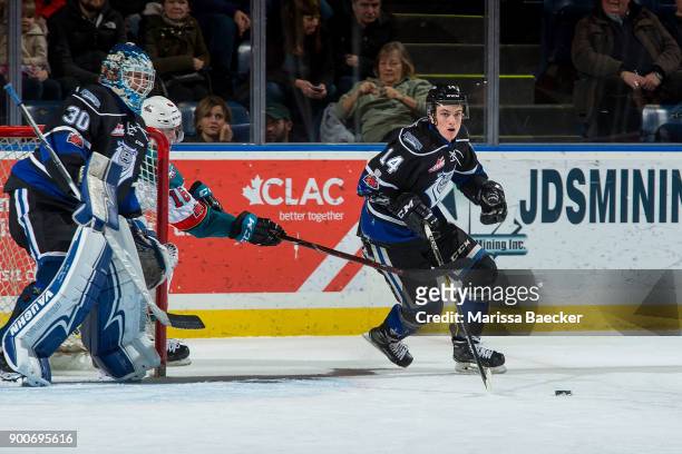 Kole Lind of the Kelowna Rockets stick checks Eric Florchuk of the Victoria Royals as he skates from behind the net with the puck at Prospera Place...