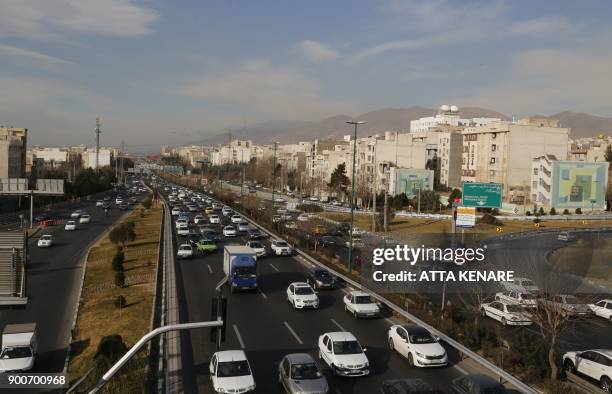 General vew shows traffic on a main road in Tehran on January 3, 2018. Tens of thousands were gathering in cities across the country in a massive...