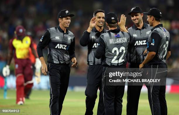 New Zealand's Anaru Kitchen celebrates with teammates after taking the wicket of West Indies batsman Rovman Powell during the third Twenty20...