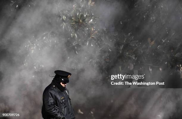 Law enforcement officer stands in front of steam outside the U.S. Department of Justice on a frigid Tuesday January 02, 2018 in Washington, DC.