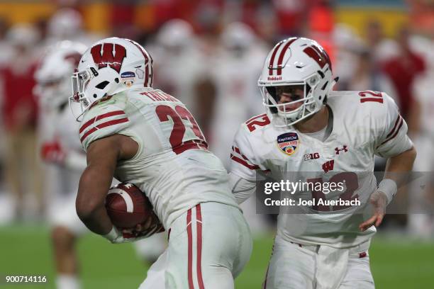 Alex Hornibrook hands the ball off to Jonathan Taylor of the Wisconsin Badgers against the Miami Hurricanes during the 2017 Capital One Orange Bowl...