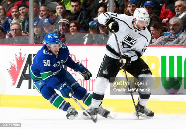 Brendan Gaunce of the Vancouver Canucks checks Alec Martinez of the Los Angeles Kings during their NHL game at Rogers Arena December 30, 2017 in...