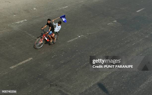 Indian youths carry Republican Party of India flag during a protest along the Eastern expressway during a protest in Mumbai on January 3, 2018....